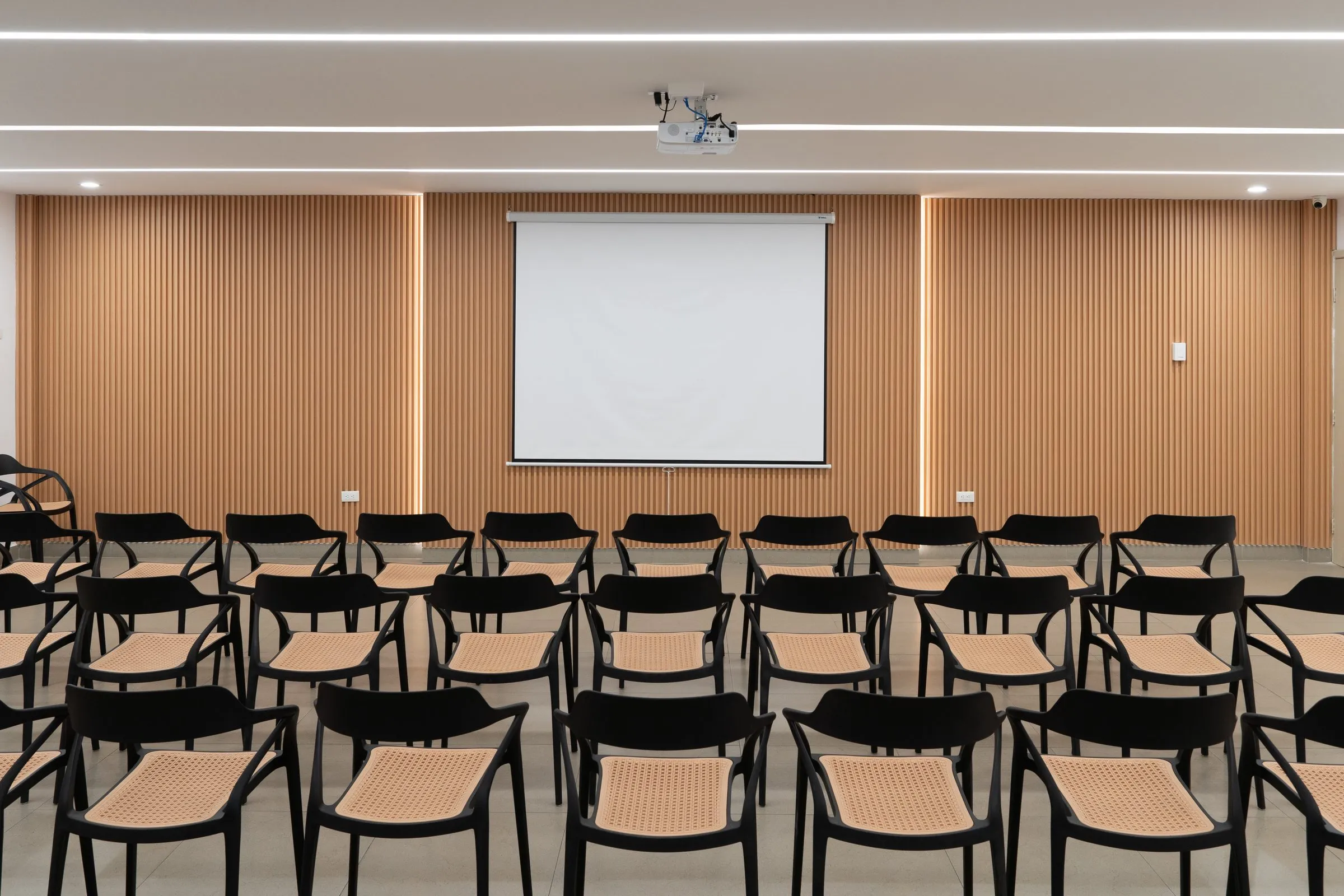 Auditorio de Dicentro con pantalla de proyección y filas de sillas
